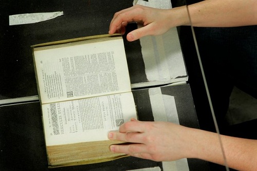 A librarian in Ann Arbor, Mich., using a desktop machine to digitize a rare, centuries-old Bible.